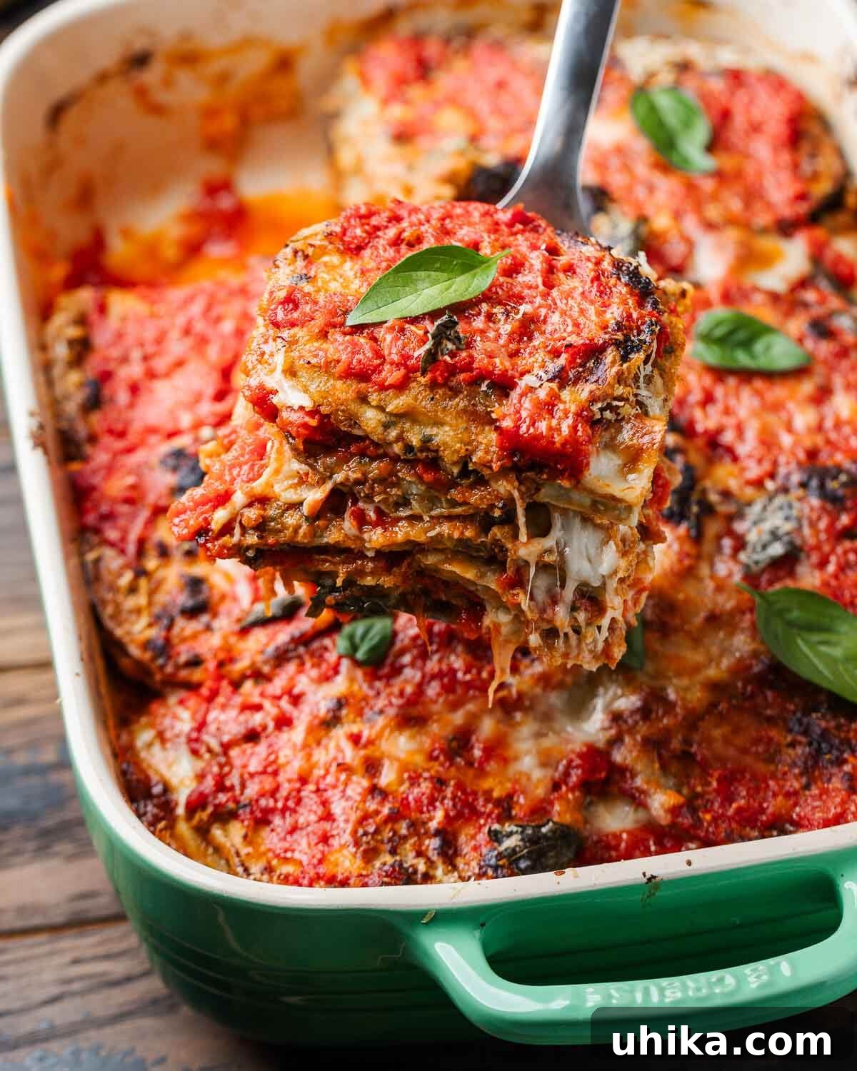 Golden Baked Eggplant Parmesan 10 Spatula pulling out piece of eggplant parmesan from baking dish.