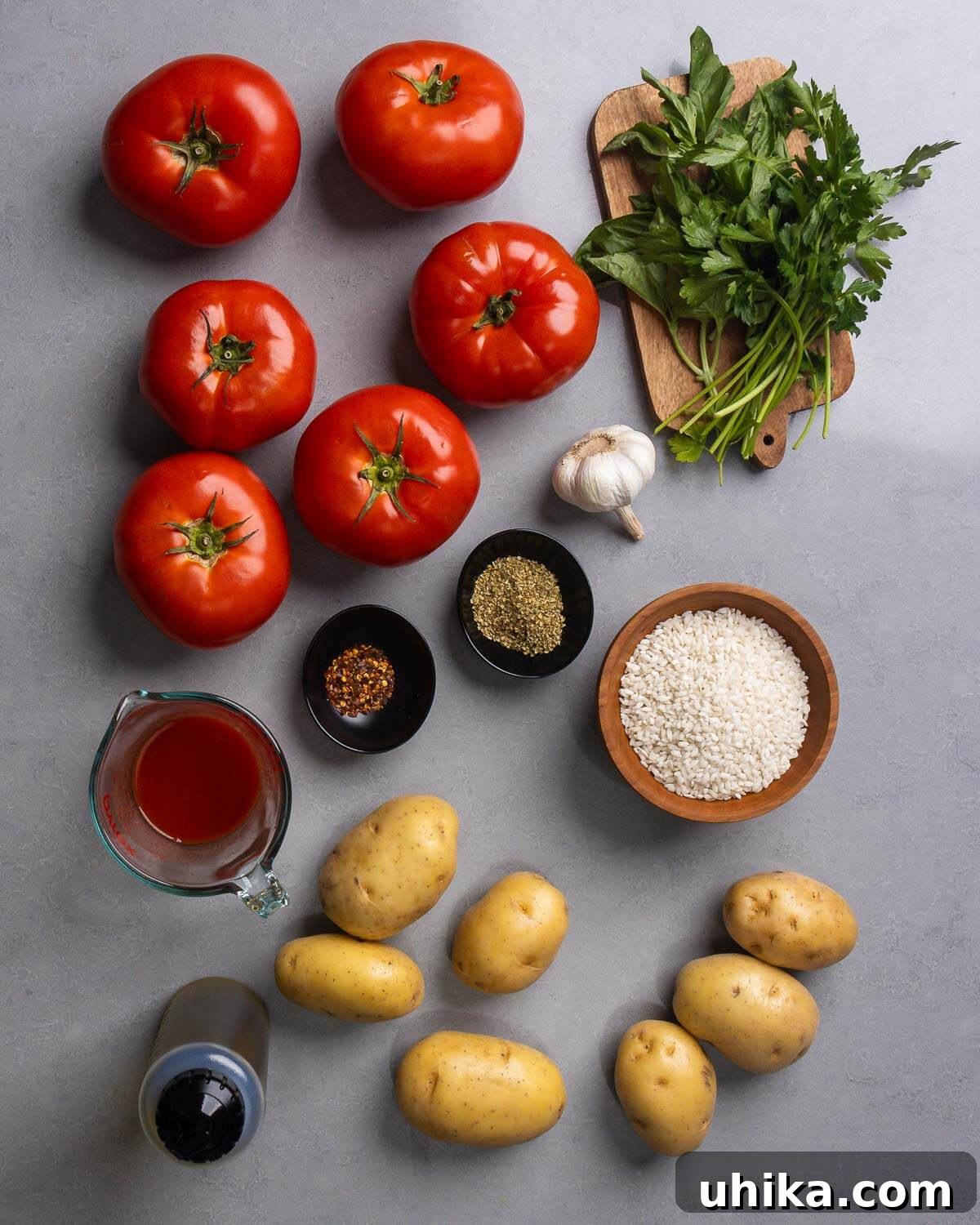 Sun-Drenched Roman Stuffed Tomatoes 4 Ingredients shown: large tomatoes, basil and parsley, passata, hot red pepper flakes, oregano, garlic, rice, olive oil, and potatoes.