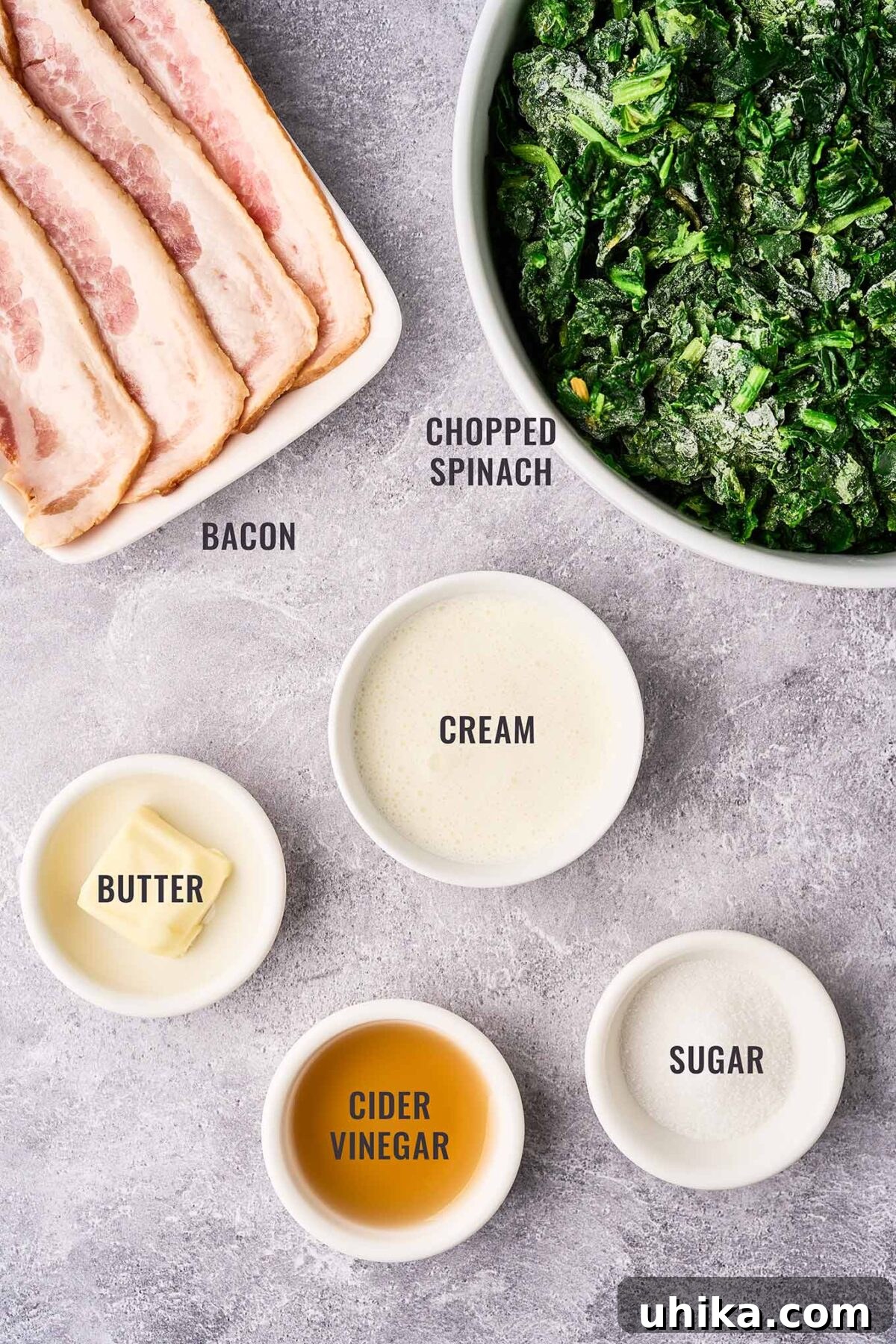 Crispy Bacon and Tangy Spinach Delight 3 An overhead view of the ingredients for sweet and sour spinach with bacon; frozen chopped spinach, bacon, butter, cream, sugar, and cider vinegar.