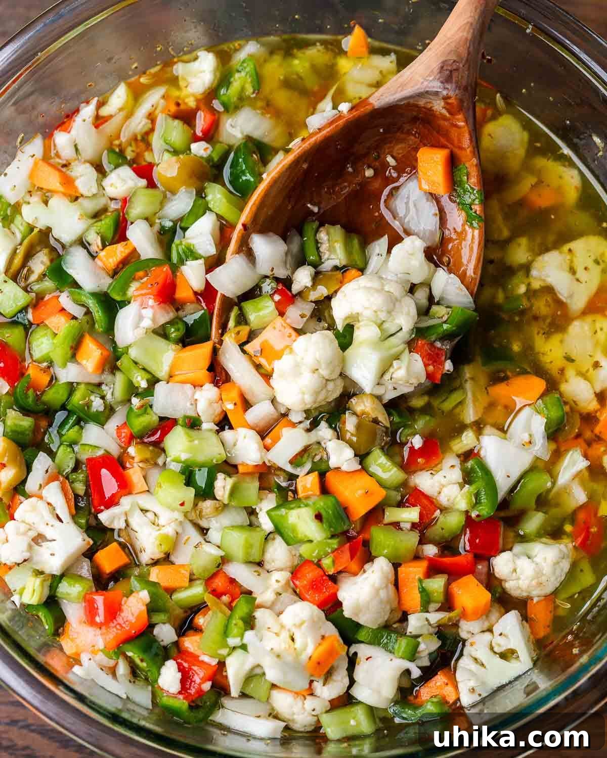 Zesty Garden Relish 7 A large ceramic bowl filled with vibrant giardiniera, served with a wooden ladle, ready to be enjoyed.