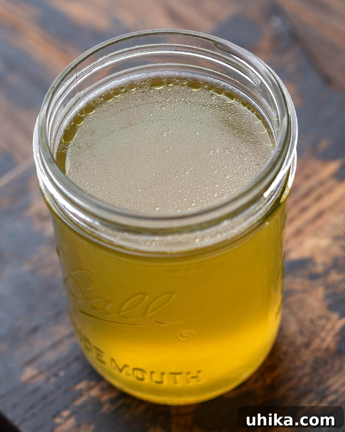 Homemade Liquid Gold 2 Mason jar filled with homemade chicken stock, showcasing its golden hue and inviting texture.