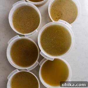 Multiple containers of chicken stock on counter.
