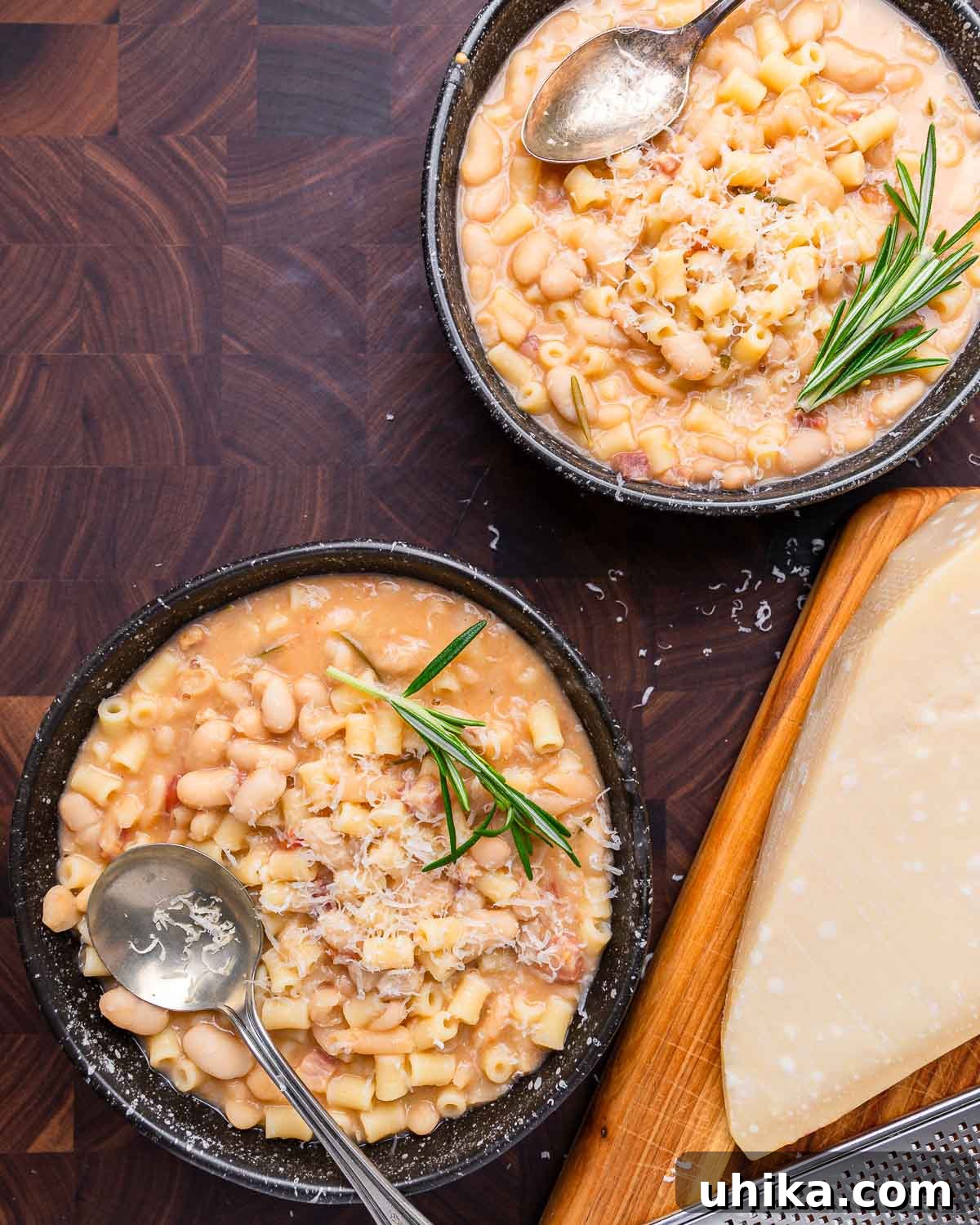 Pasta Fazool: The Dish, The Dialect, The Delight 3 Overhead shot of two bowls of pasta fagioli and block of parmesan on cutting board.