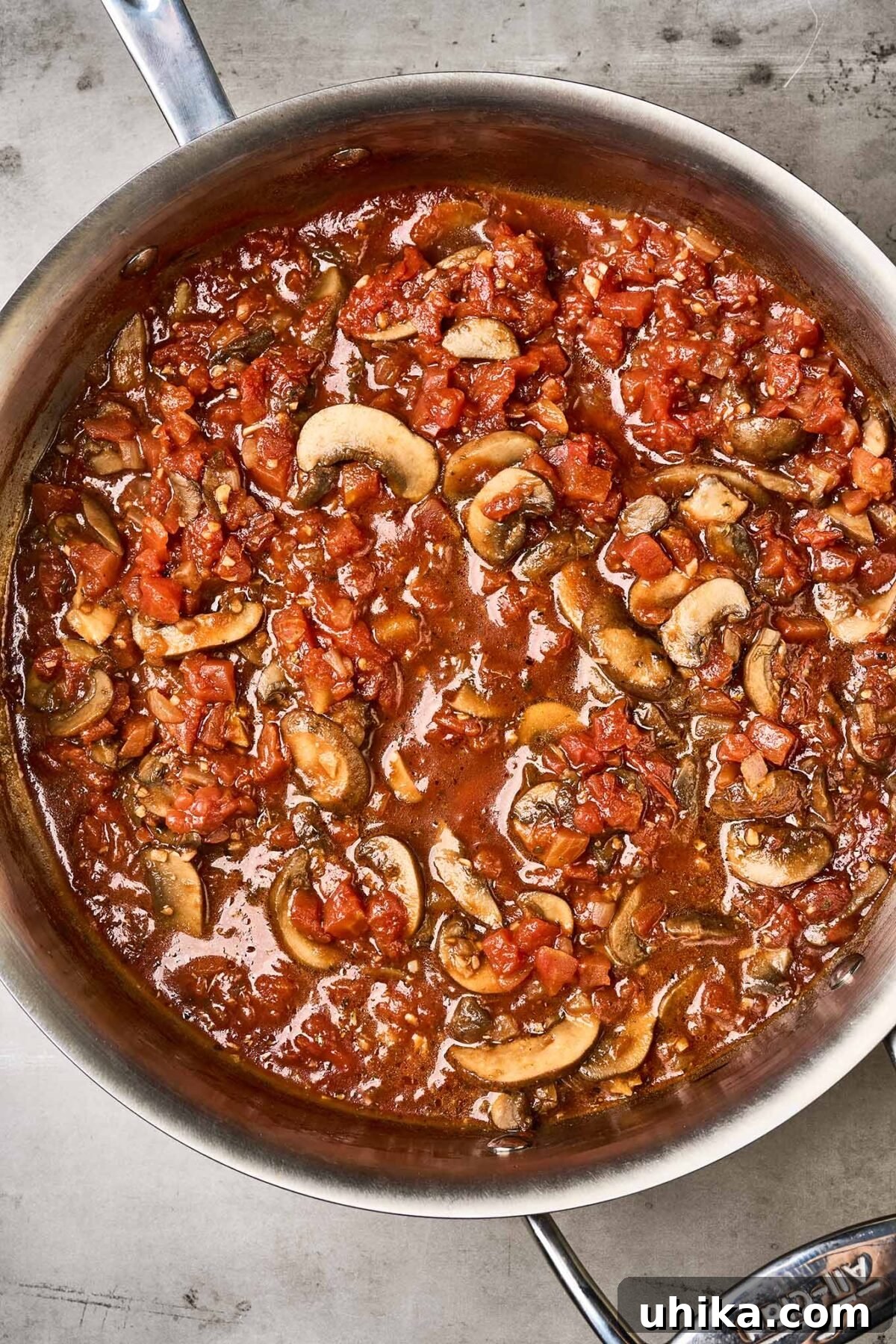 Savory Eggplant Mushroom Pasta 4 An overhead view of a pan filled with rich mushroom and tomato sauce, ready for the roasted eggplant to be added.