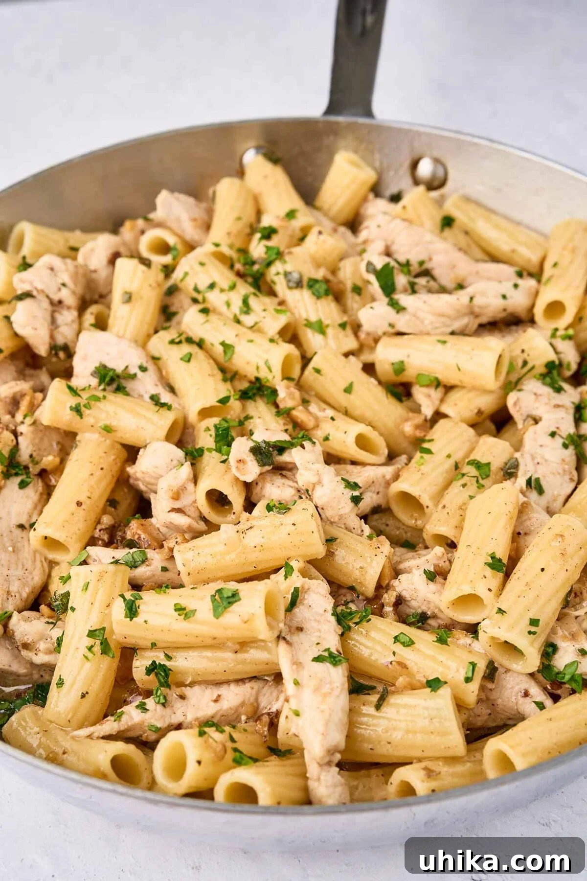 Nutty Brown Butter Chicken Pasta 8 The final step for preparing brown butter chicken pasta - combining the cooked pasta, brown butter, shallots, walnuts, and herbs, and sautéed chicken, then dusting it with nutmeg.