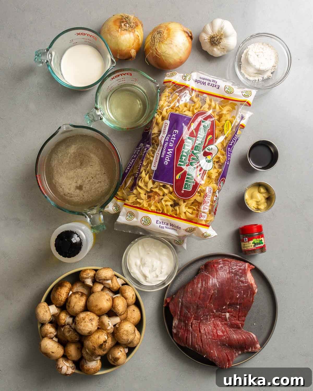 Velvety Beef Stroganoff 2 Ingredients shown: cream, wine, onion, garlic, flour, egg noodles, beef stock, sour cream, mushrooms, olive oil, flank steak, mustard, spices, and worcestershire sauce.