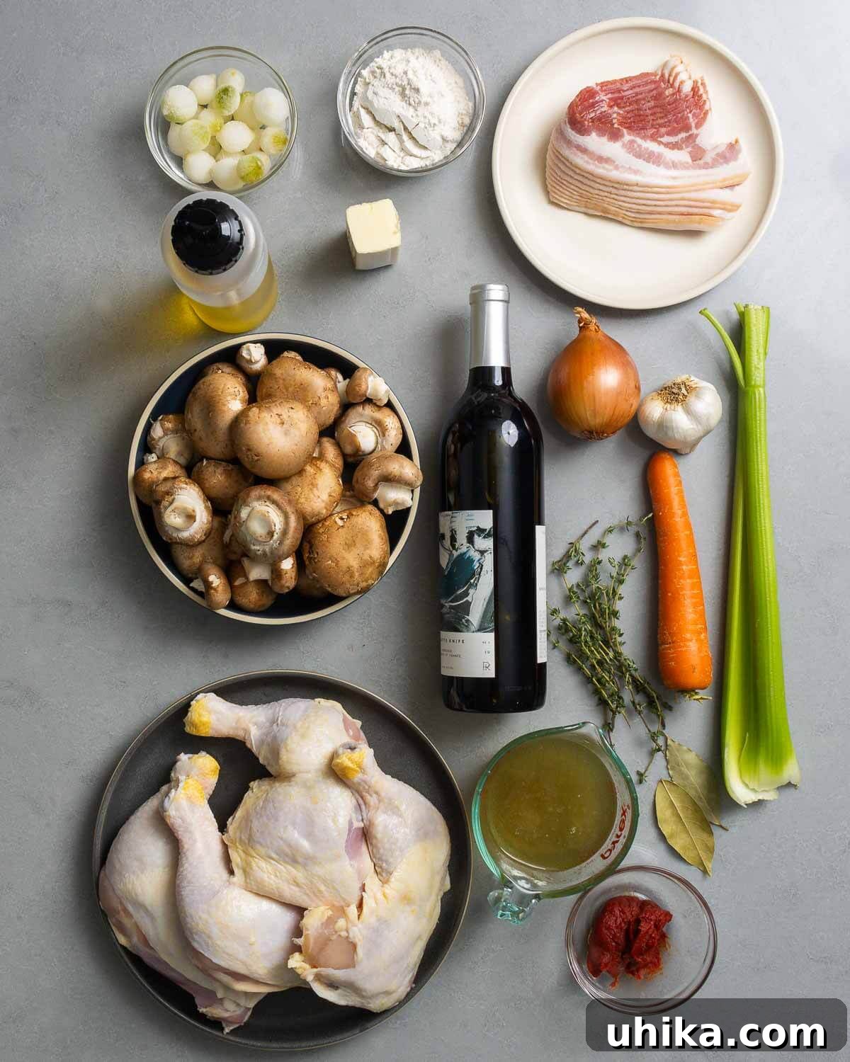 Classic French Wine-Braised Chicken 2 A collage of fresh ingredients for Coq au Vin including chicken, red wine, bacon, mushrooms, pearl onions, carrots, celery, garlic, tomato paste, flour, chicken stock, olive oil, and fresh herbs like thyme.