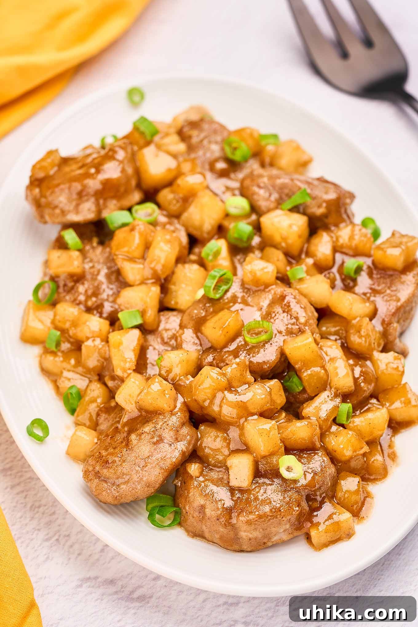 Island-Style Pineapple Pork Skillet 5 Pork medallions coated in pineapple rum sauce and garnished with fresh sliced scallions, presented beautifully for a Caribbean-inspired pineapple pork dinner.