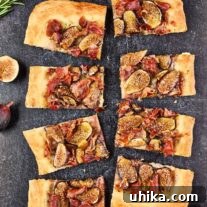 Gourmet Fig Prosciutto Brie Pizza 7 Slices of fig and prosciutto pizza on a slate background surrounded by fresh figs and sprigs of rosemary.