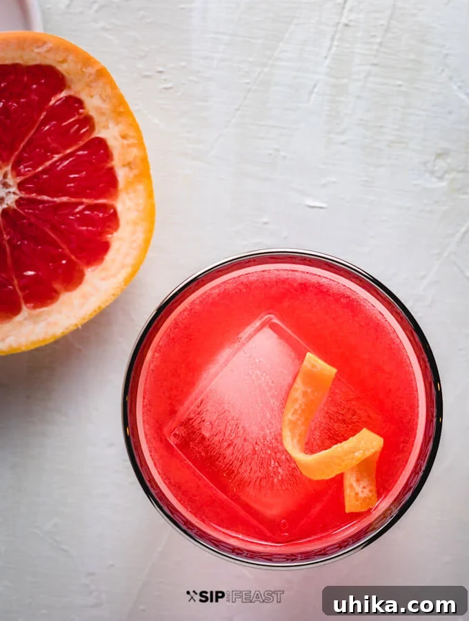 Grapefruit Gin Negroni Twist 2 A chilled glass of the vibrant Grapefruit Gin Negroni, garnished with a sophisticated twist of grapefruit peel, ready to be enjoyed.