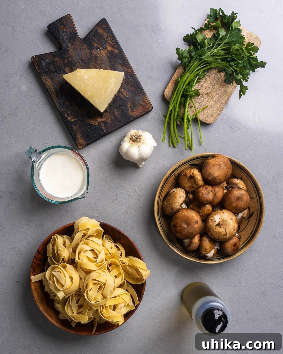 Luscious Garlic Mushroom Pasta 4 Ingredients shown for creamy garlic mushroom pasta: Pecorino Romano, garlic, parsley, heavy cream, cremini mushrooms, pappardelle pasta, and olive oil.