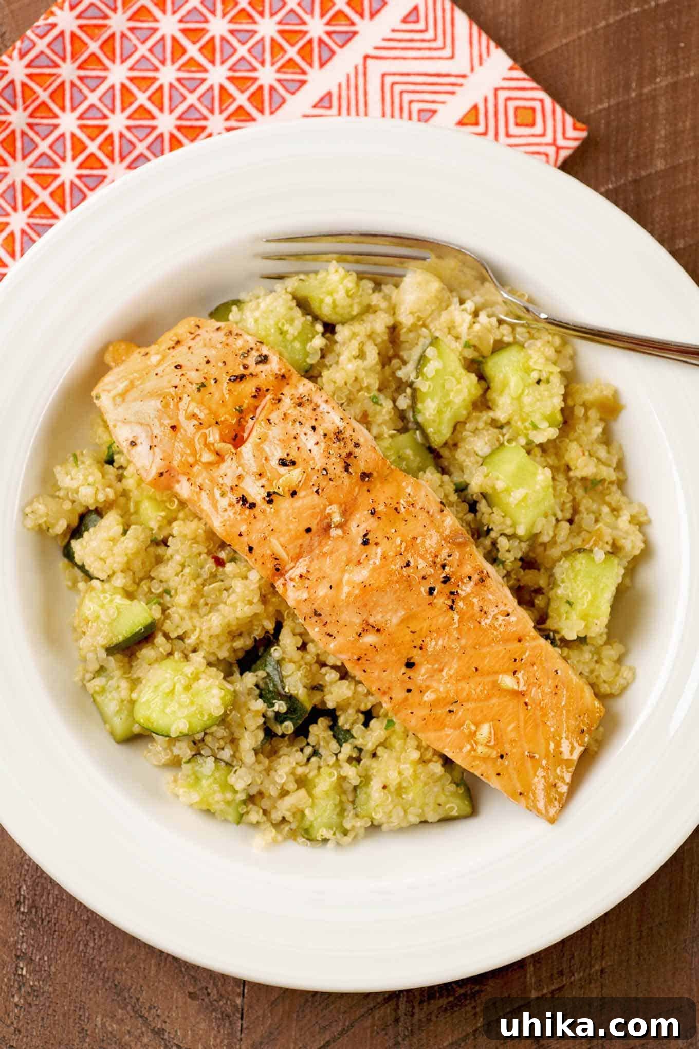 Sweet and Savory Honey Garlic Salmon Quinoa Bowl 2 A vibrant bowl featuring a honey-garlic glazed salmon fillet resting on a bed of fluffy quinoa and perfectly roasted zucchini, garnished for a fresh touch.