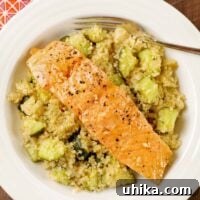 Sweet and Savory Honey Garlic Salmon Quinoa Bowl 3 An overhead view of a bowl of quinoa combined with roasted zucchini and topped with a roasted, honey-glazed salmon fillet.