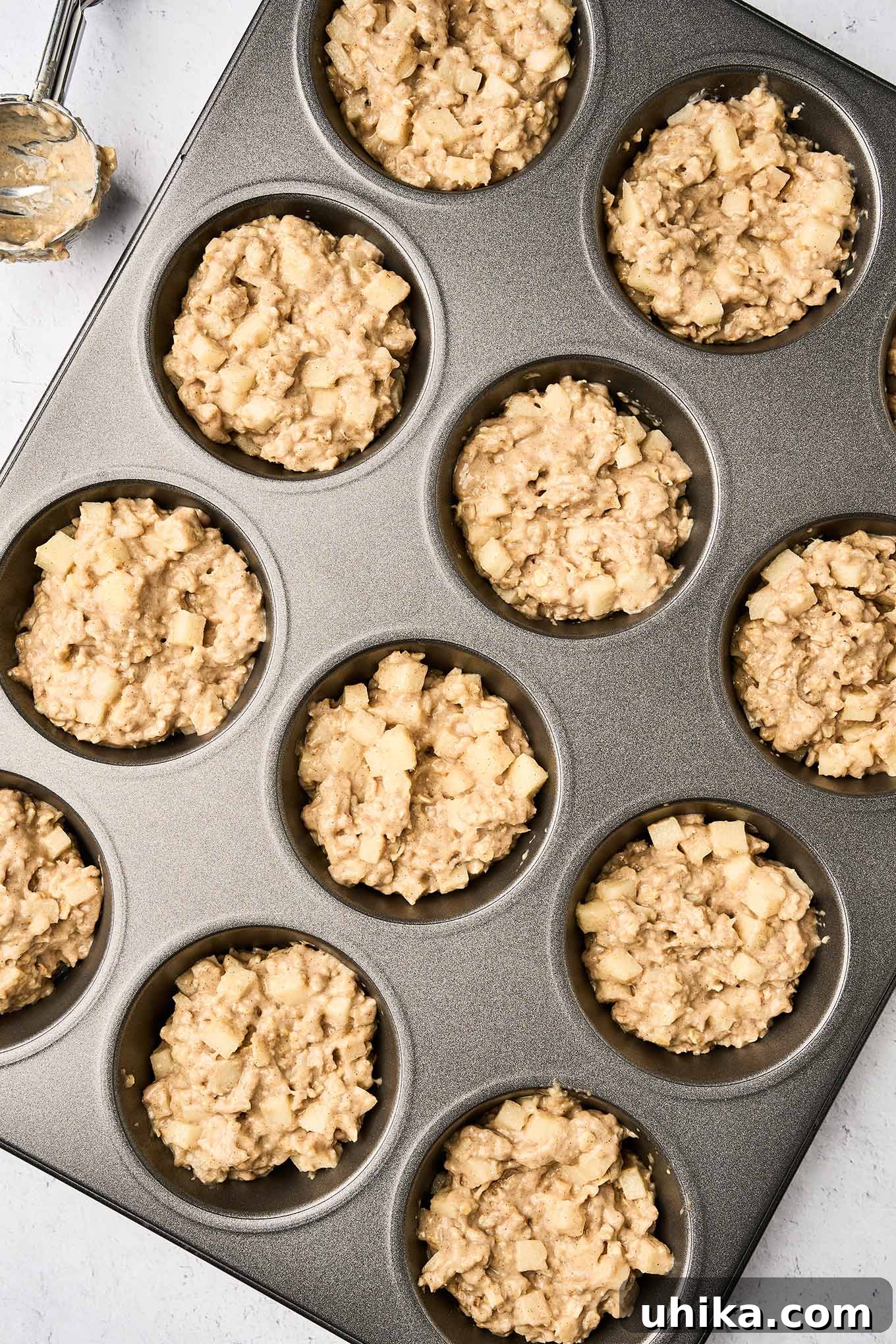 Cozy Apple Cinnamon Oat Muffins 5 Apple cinnamon oatmeal muffin batter perfectly scooped into the muffin tin, poised for baking, promising a golden and delightful outcome.