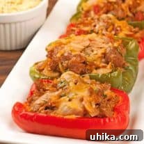 Hearty Turkey Sausage & Orzo Pepper Boats 3 Turkey sausage and orzo stuffed bell peppers baked with melted cheese, served on a rectangular white platter.