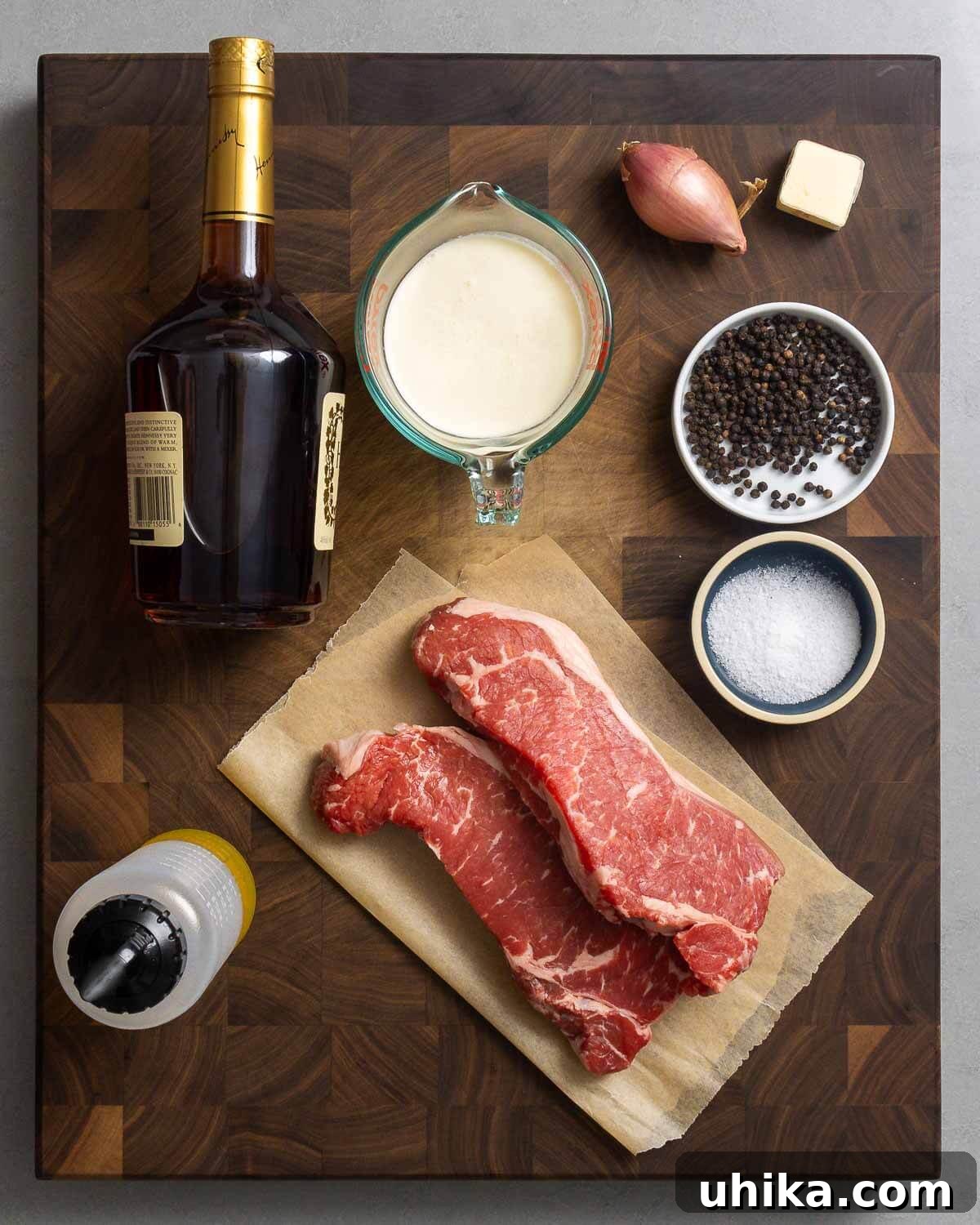 Pepper Crusted Steak 3 Ingredients shown: cognac, heavy cream, shallot, butter, peppercorns, salt, New York strip steaks, and olive oil.