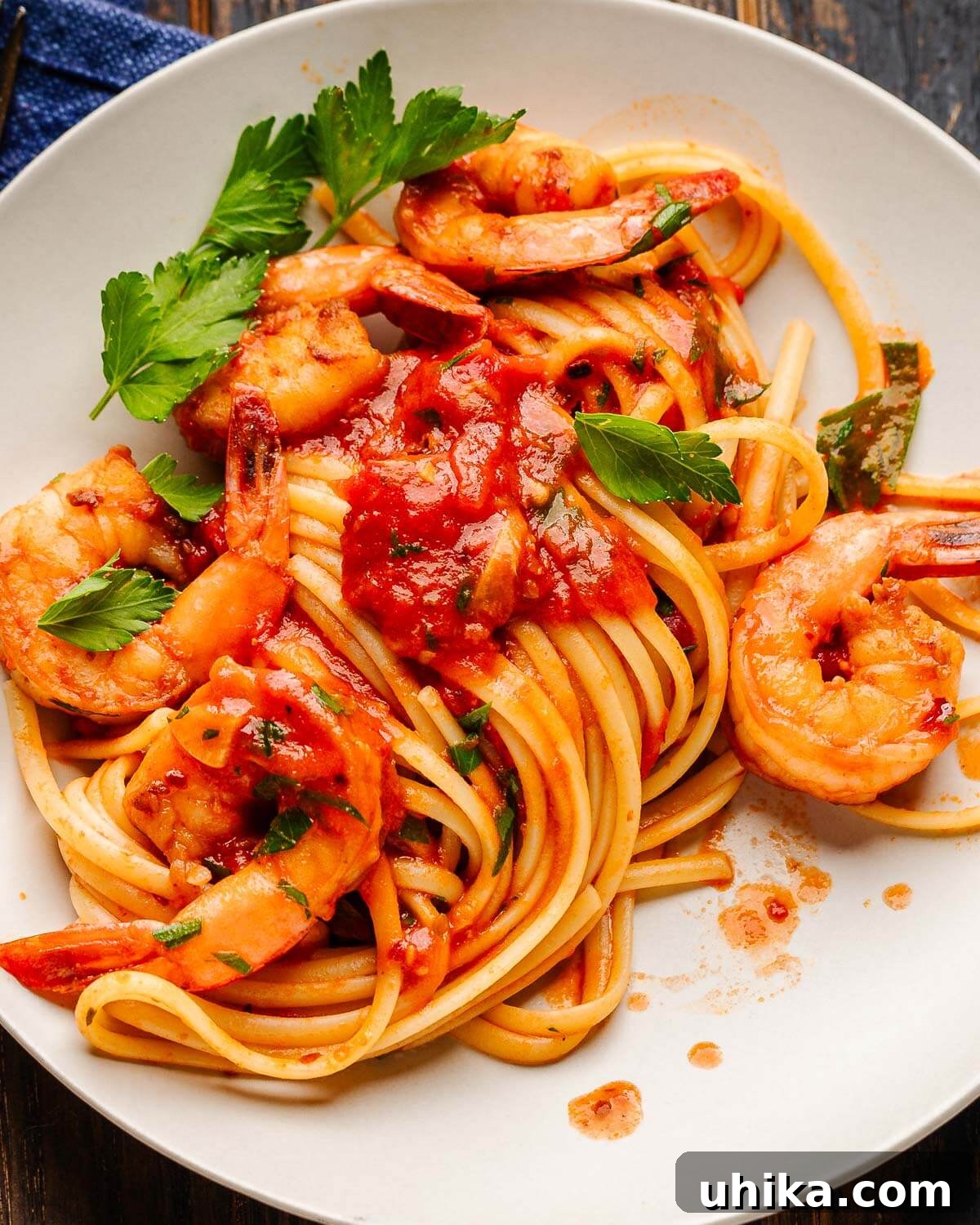 Fiery Fra Diavolo Shrimp Linguine 6 Shrimp fra diavolo on white plate with parsley garnish.