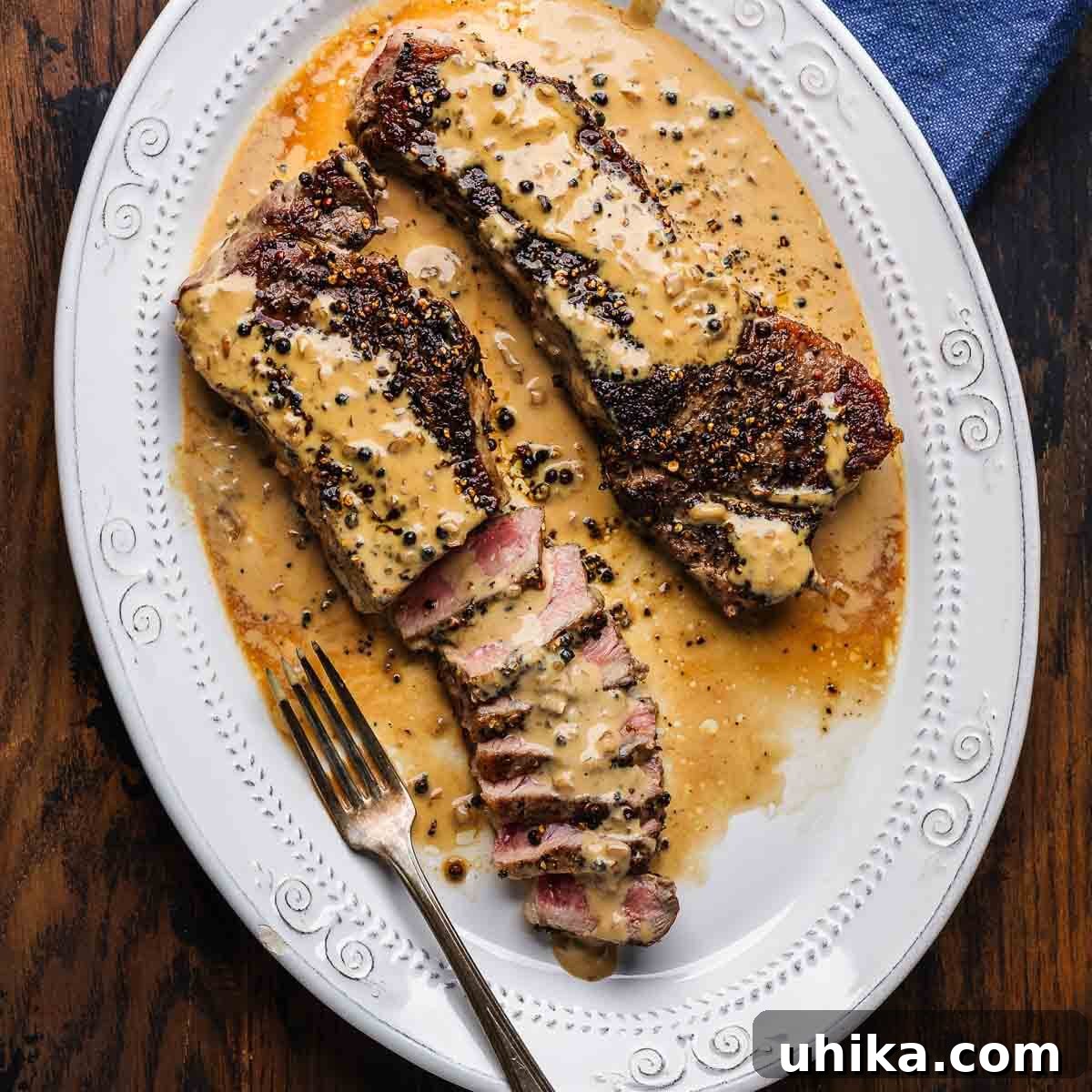 Episode 30: Dishing Out 2023's Food Trend Hits and Misses 2 Steak au poivre in white platter on table. A classic French dish that never goes out of style, showcasing timeless culinary appeal.