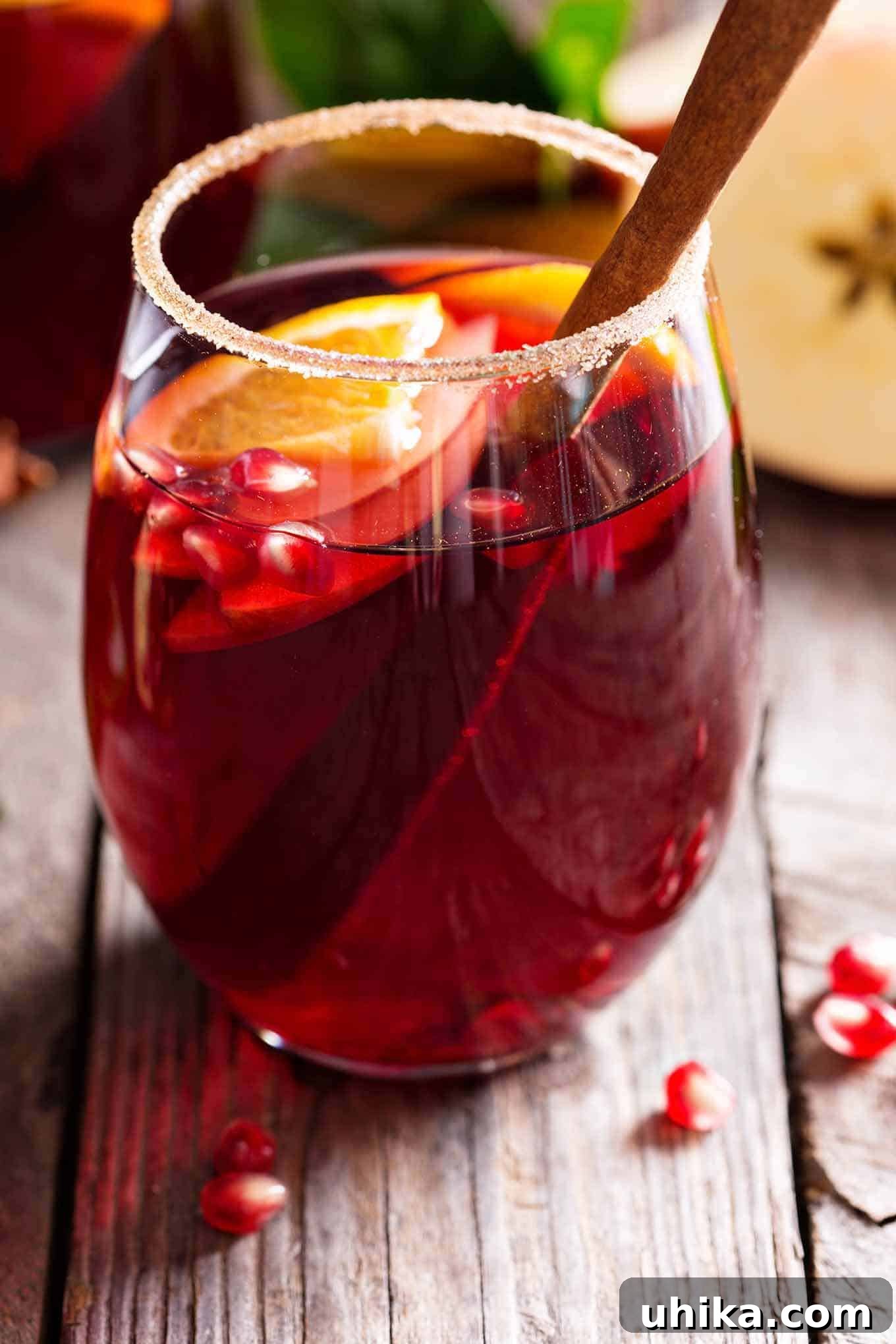 Fireside Sangria 2 A beautiful glass of Winter Spice Sangria garnished with clementines, cranberries, and cinnamon sticks, perfect for holiday gatherings.