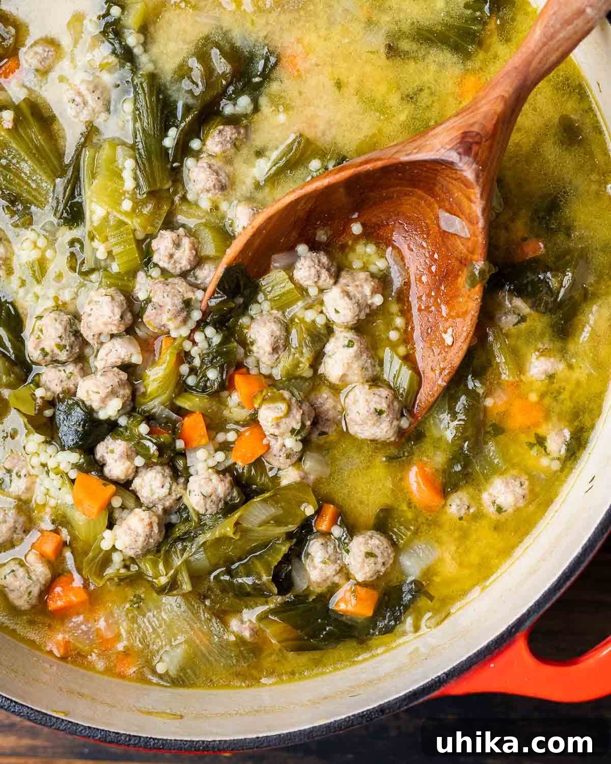 Italian Wedding Feast Soup 2 Large pot of Italian wedding soup with wooden ladle scooping out the meatballs.