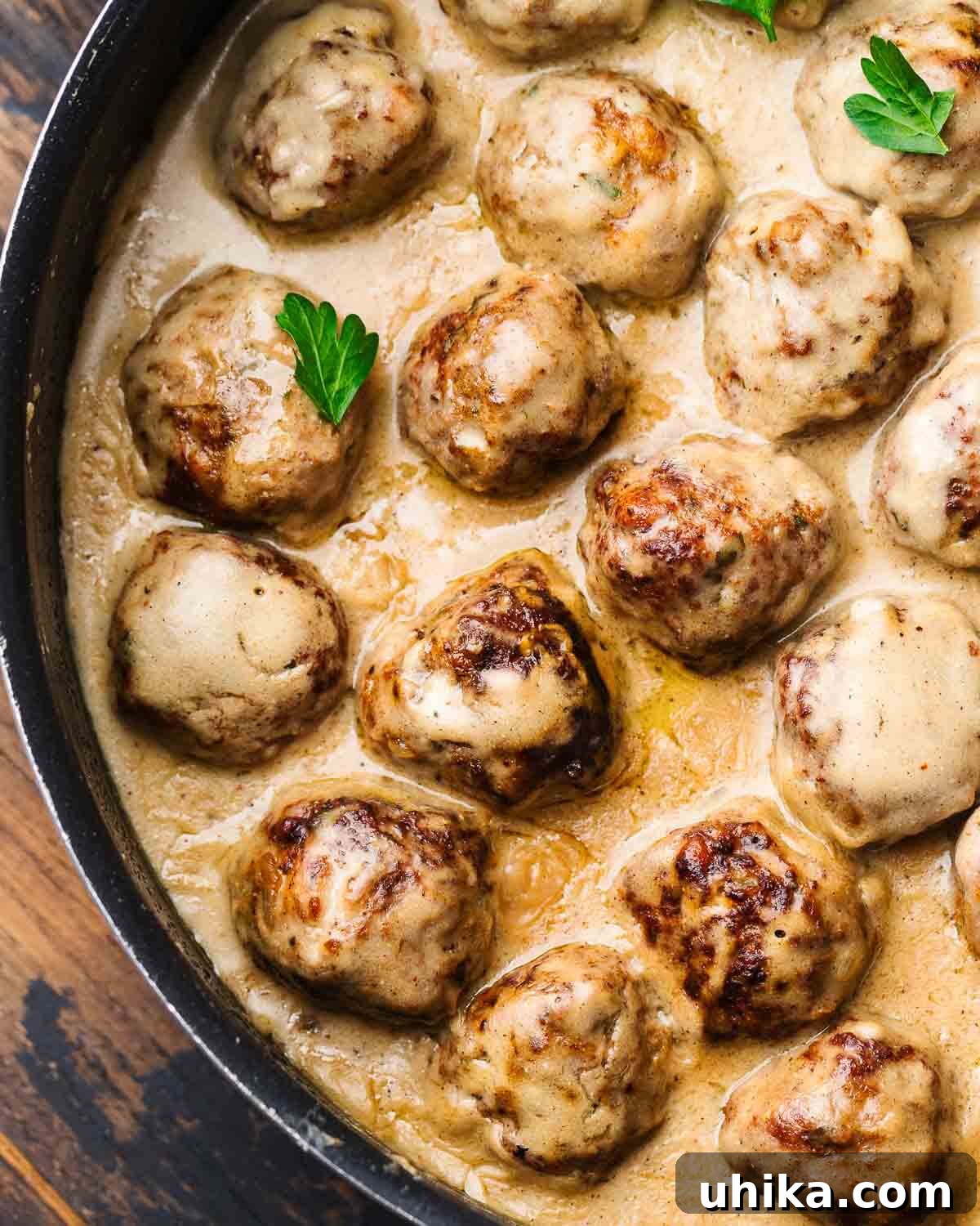 Nordic Meatball Delight 2 Hearty Swedish meatballs simmering in a rich, creamy brown gravy in a black pan, ready to be served.