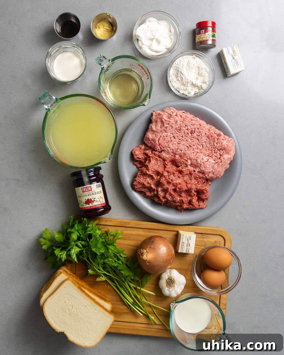 Nordic Meatball Delight 3 A flat lay photograph showcasing all the ingredients required for Swedish Meatballs, including ground beef and pork, bread, milk, onions, garlic, eggs, allspice, nutmeg, butter, flour, chicken stock, heavy cream, sour cream, Dijon mustard, Worcestershire sauce, parsley, and lingonberry jam.