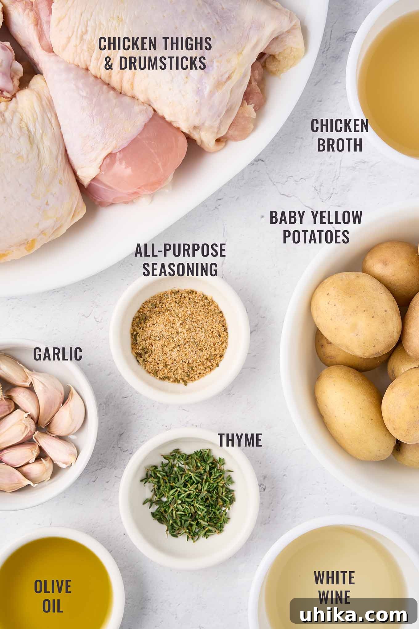 Hearty Braised Chicken and Potatoes 3 Ingredients for braised chicken legs with potatoes, including chicken thighs, garlic, thyme, baby potatoes, broth, seasoning, olive oil, and white wine.
