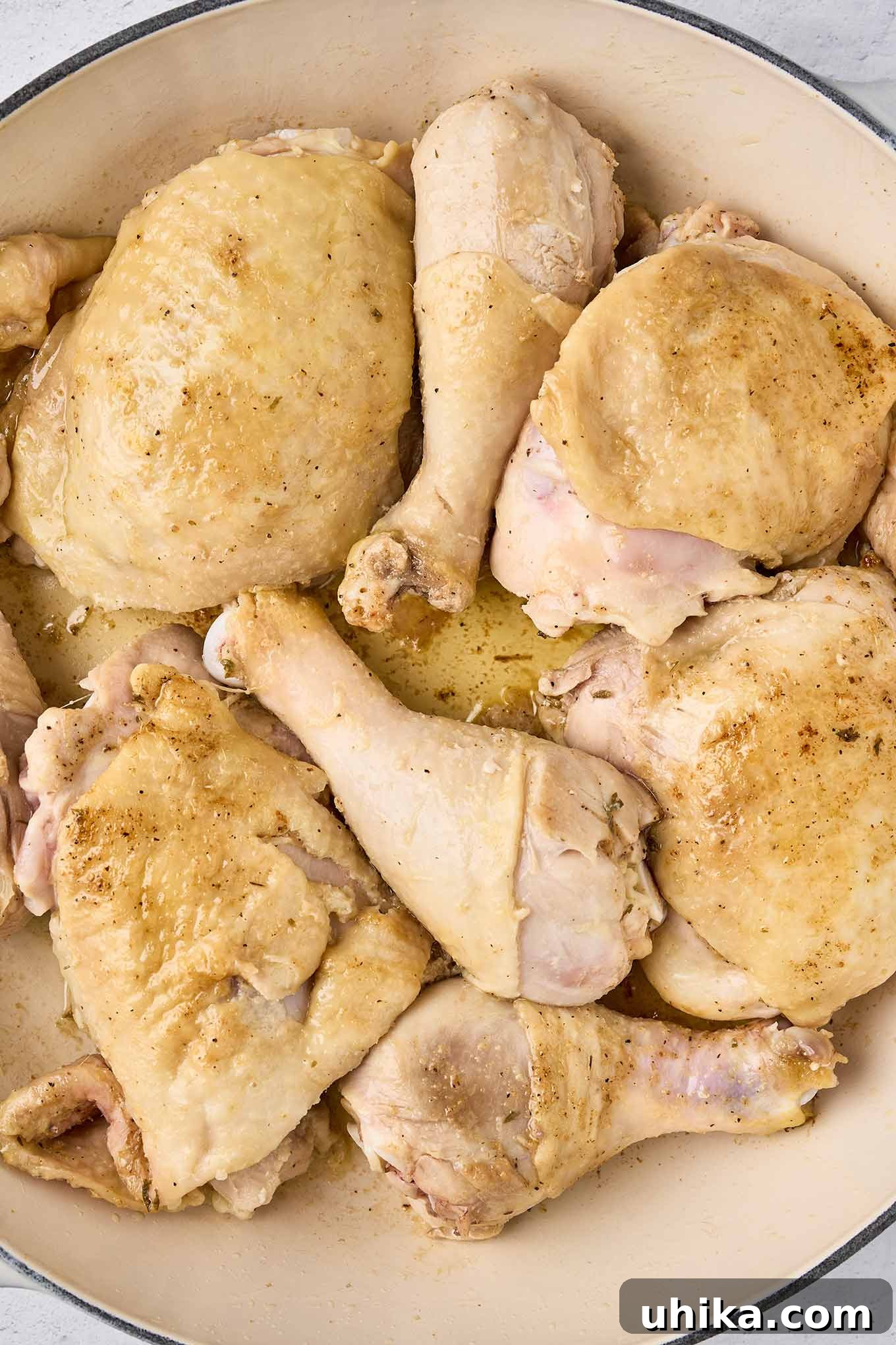 Hearty Braised Chicken and Potatoes 4 Chicken thighs and drumsticks browning in a large sauté pan for braised chicken legs.