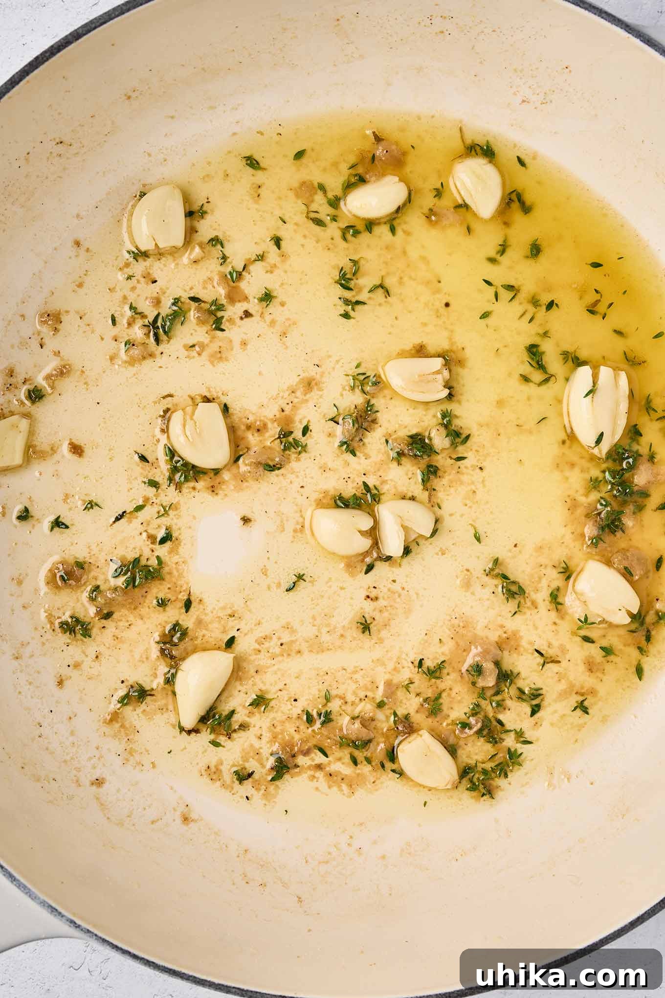 Hearty Braised Chicken and Potatoes 5 Crushed garlic cloves and fresh thyme sautéing in the pan after browning the chicken.