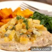 Pan-Seared Pork Chops with Caramelized Pears 4 A plate with a boneless pork chop, pan-seared and topped with sautéed chopped pears, blue cheese, and thyme with side dishes of sweet potatoes and spinach.