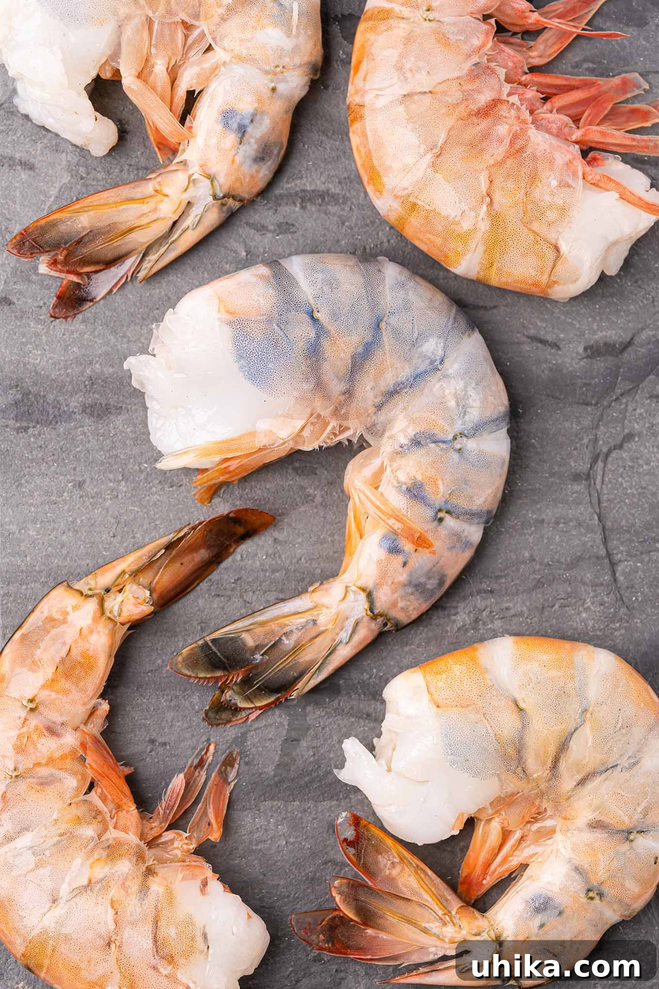Oven-Baked Shrimp Treasures 3 Raw colossal shrimp arranged on a slate board, ready for a delicious baked stuffed shrimp recipe.
