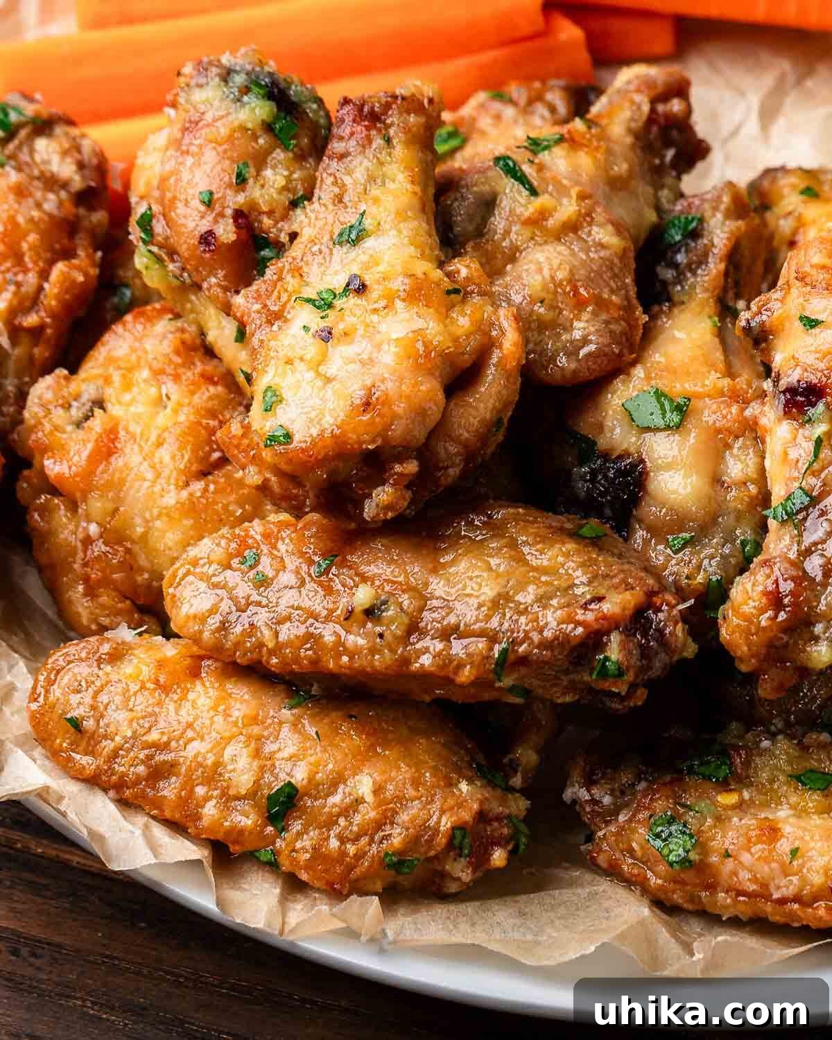 Podcast 36: Score Big with These 5 Must-Make Super Bowl Recipes 2 Plate of garlic parmesan chicken wings, perfectly golden and coated in cheese and herbs.