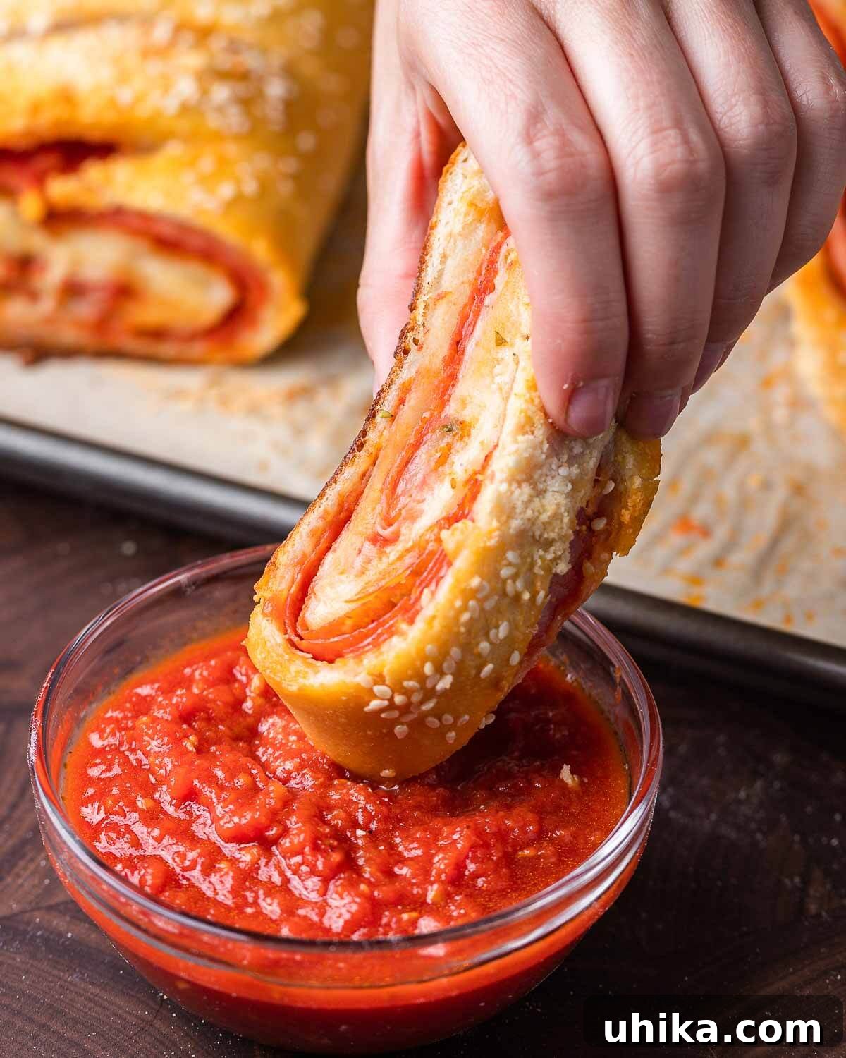 Podcast 36: Score Big with These 5 Must-Make Super Bowl Recipes 3 Hands dipping a slice of homemade stromboli into marinara sauce.