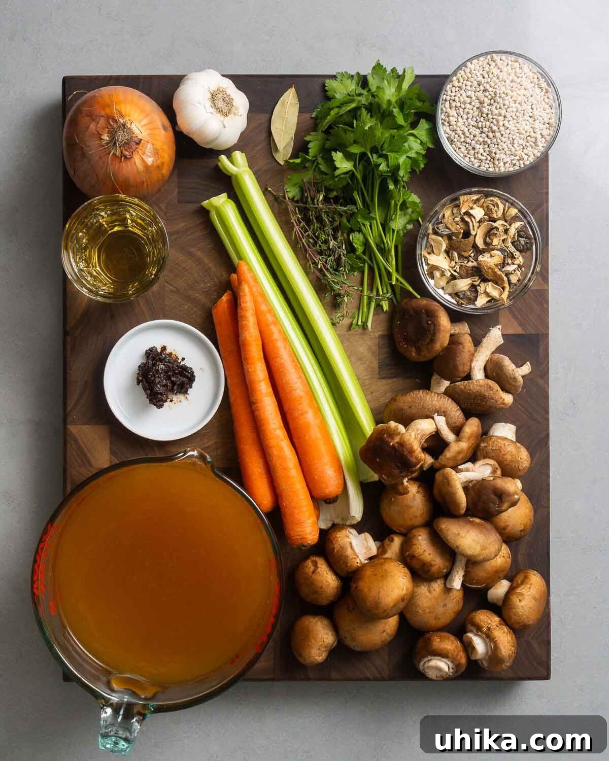 Hearty Mushroom Barley Soup 3 Ingredients for mushroom barley soup including onions, garlic, fresh and dried mushrooms, carrots, celery, herbs, wine, miso paste, and vegetable stock.