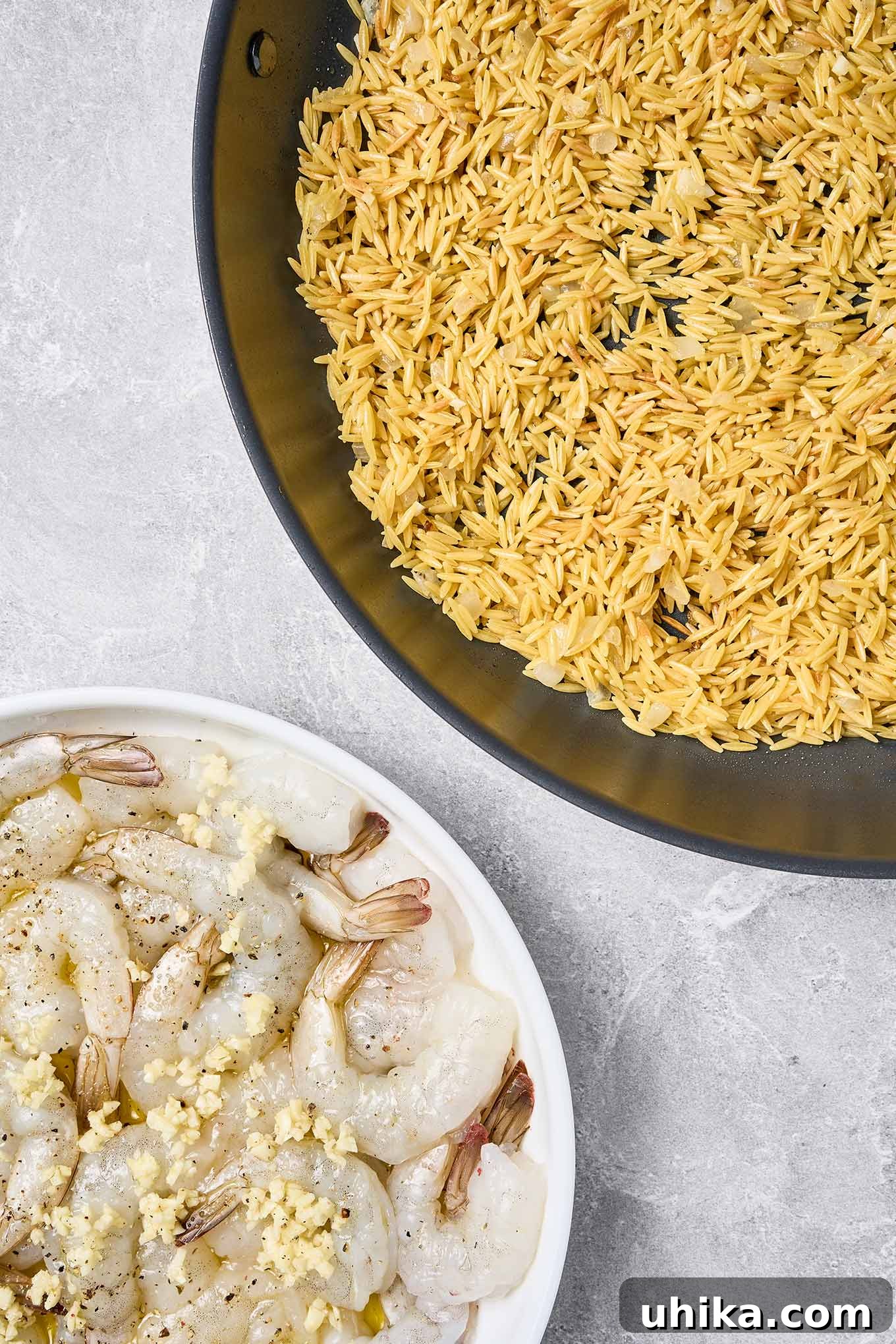 Step one of shrimp scampi with orzo: toasting orzo for flavor and marinating raw shrimp in garlic and olive oil.