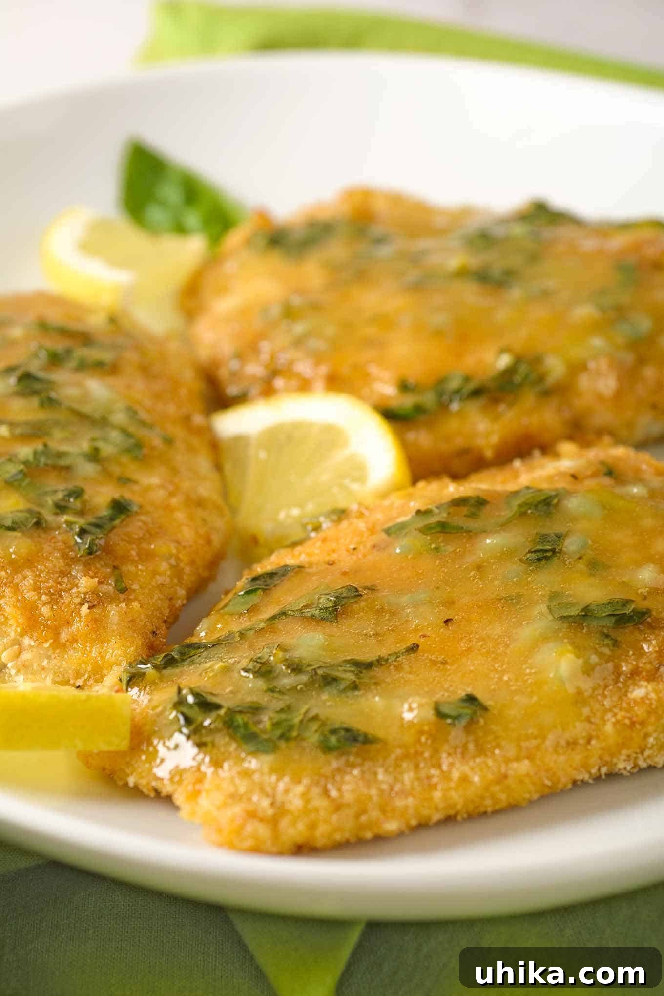 Golden Oven-Crisped Fish with Lemon Basil Butter 3 A serving of perfectly crumb-coated, oven-fried fish fillets topped generously with homemade lemon basil butter and garnished with a fresh lemon wedge.