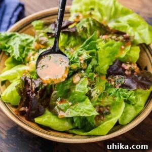 French vinaigrette spooned over salad in bowl, a perfect representation of the finished dressing.