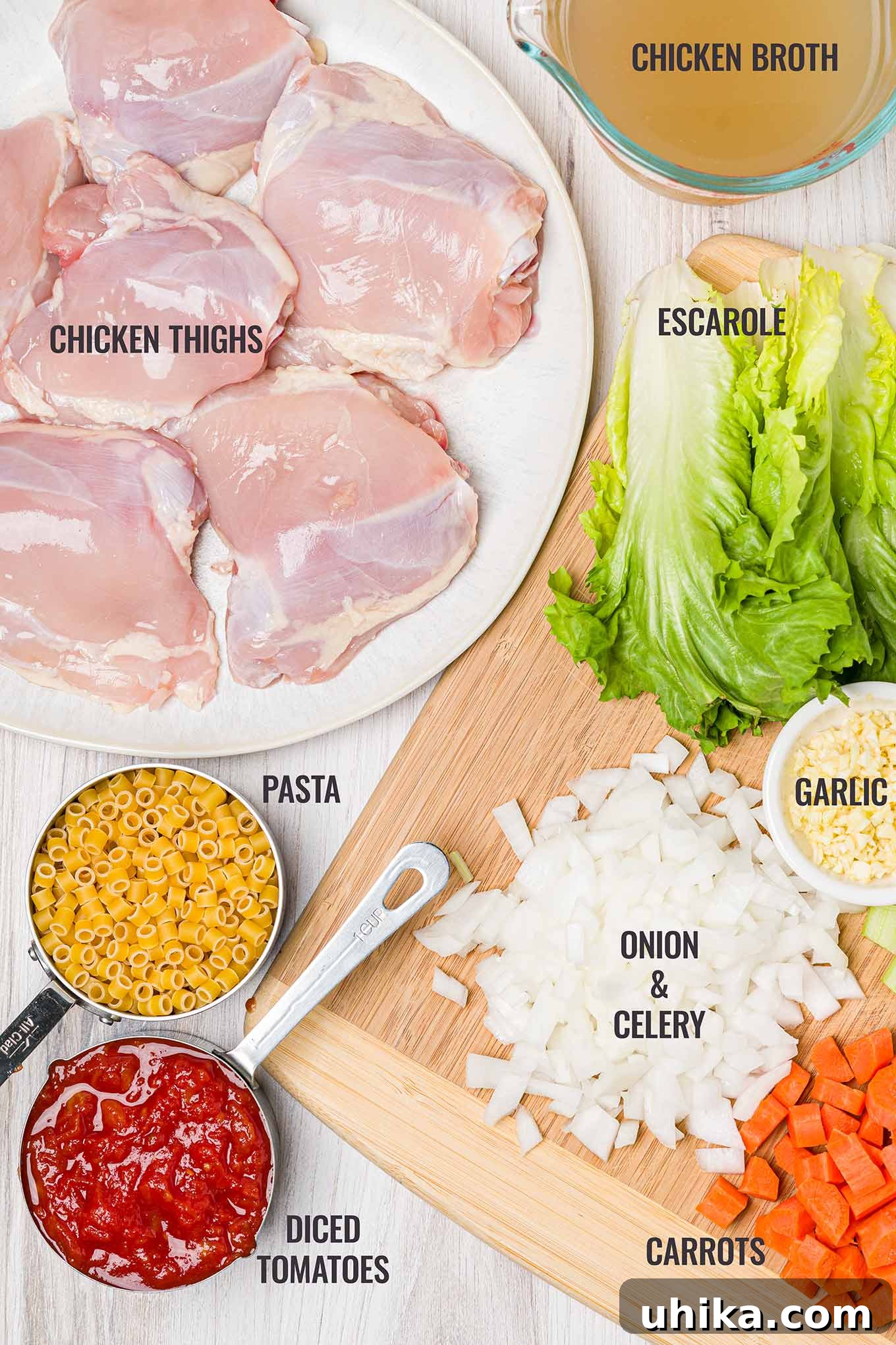Italian Chicken Soup for Instant Pot and Stovetop 3 An overhead view of Italian chicken soup ingredients including skinless chicken thighs, broth, escarole, onion, celery, garlic, carrots, tomatoes, and pasta.