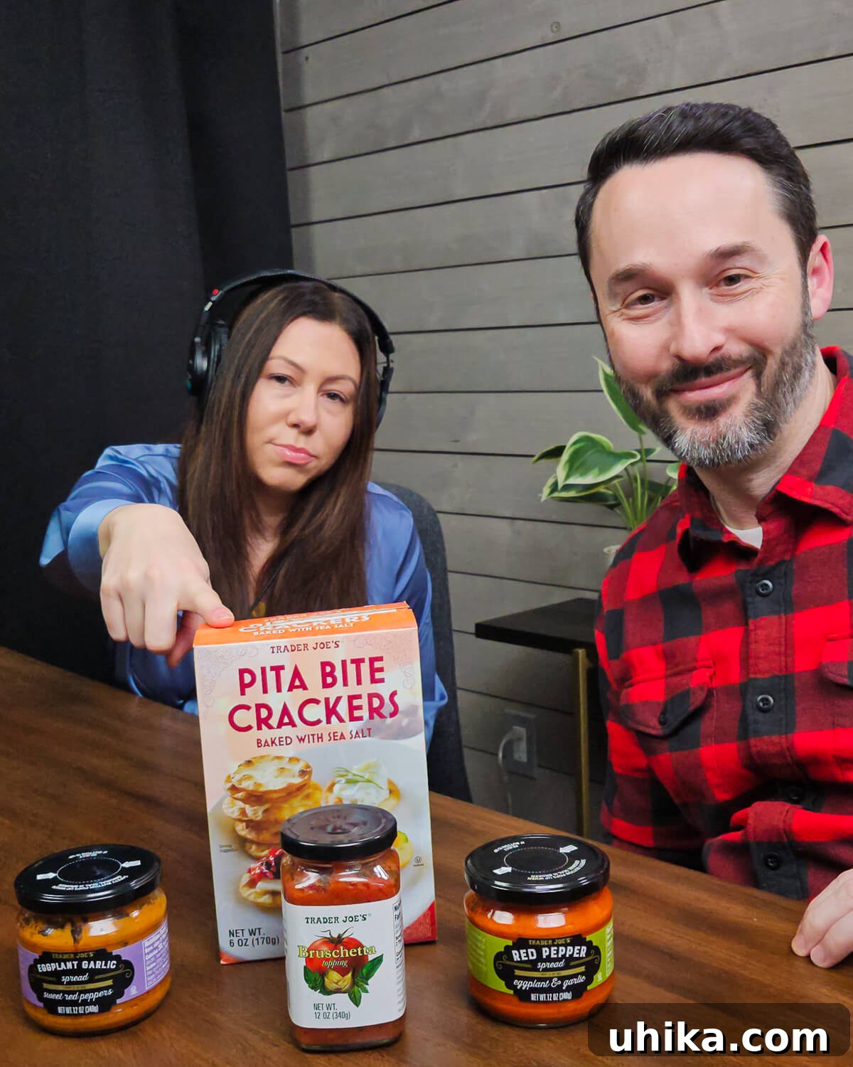 Unlock Your Inner Chef: Practical Cooking Tips and a Trader Joe's Flavor Test 2 Jim and Tara in Podcast studio with box of Trader Joe's crackers, eggplant spread, red pepper spread, and bruschetta on table during a taste test, discussing their findings.