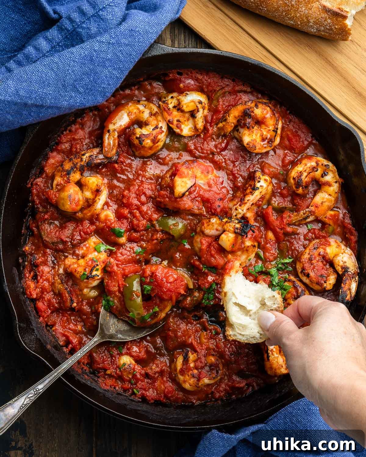 Spicy Scarlet Shrimp 2 Cast iron pan with shrimp arrabbiata and hand dipping bread into the sauce.