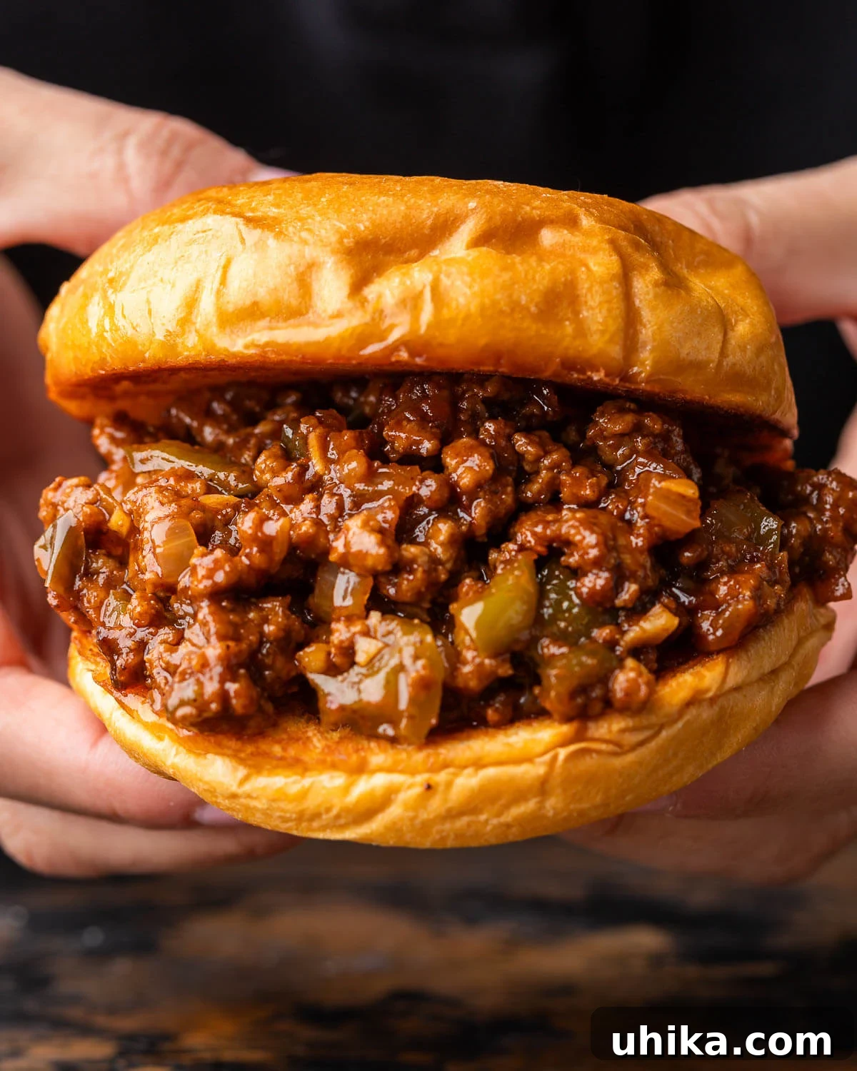 Effortless Homemade Sloppy Joes 2 Sloppy Joe sandwich held in hands, showcasing its delicious messiness.