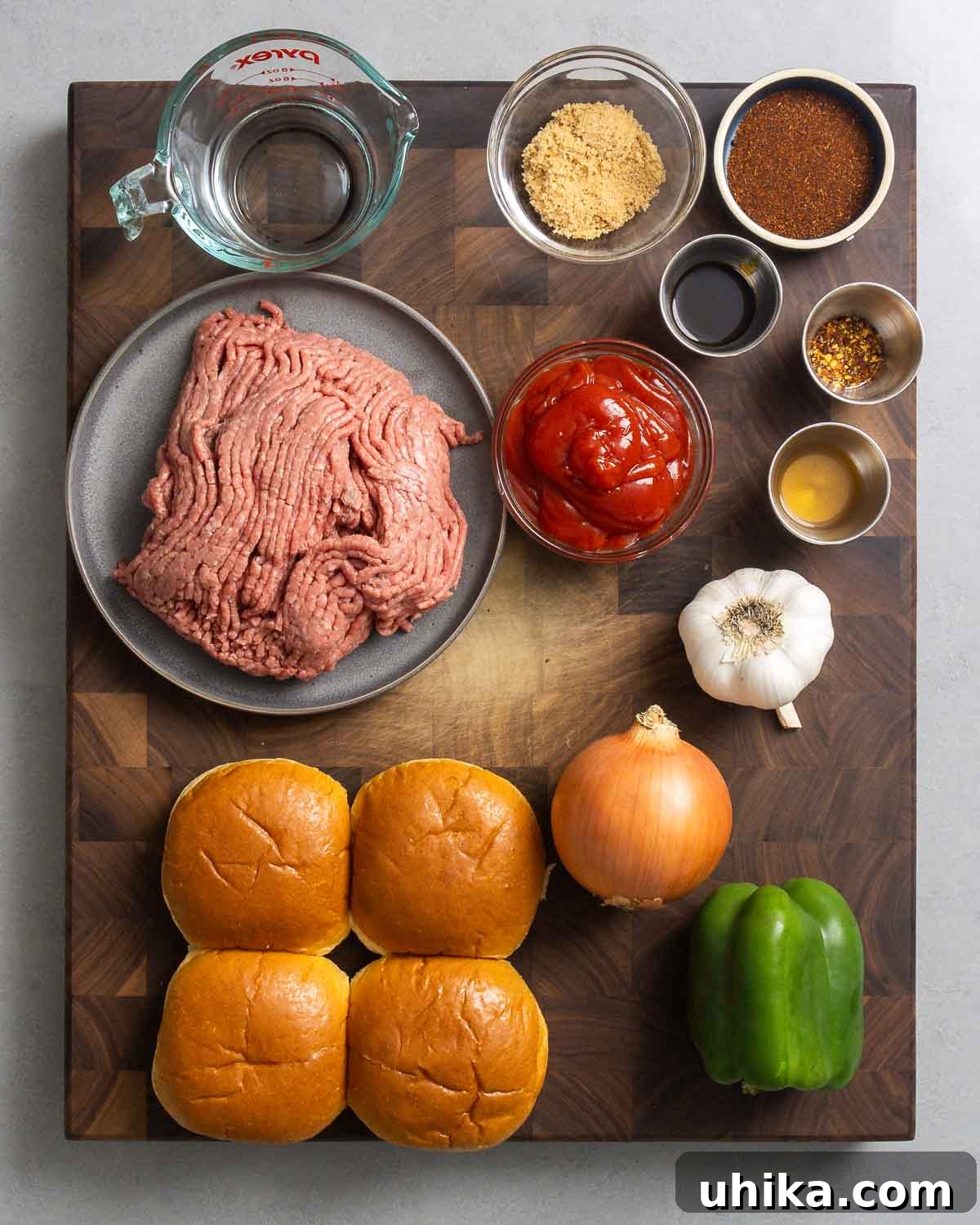 Effortless Homemade Sloppy Joes 3 Ingredients for Sloppy Joes including ground beef, onions, bell peppers, garlic, ketchup, brown sugar, cider vinegar, Worcestershire sauce, chili powder, red pepper flakes, water, and hamburger buns.