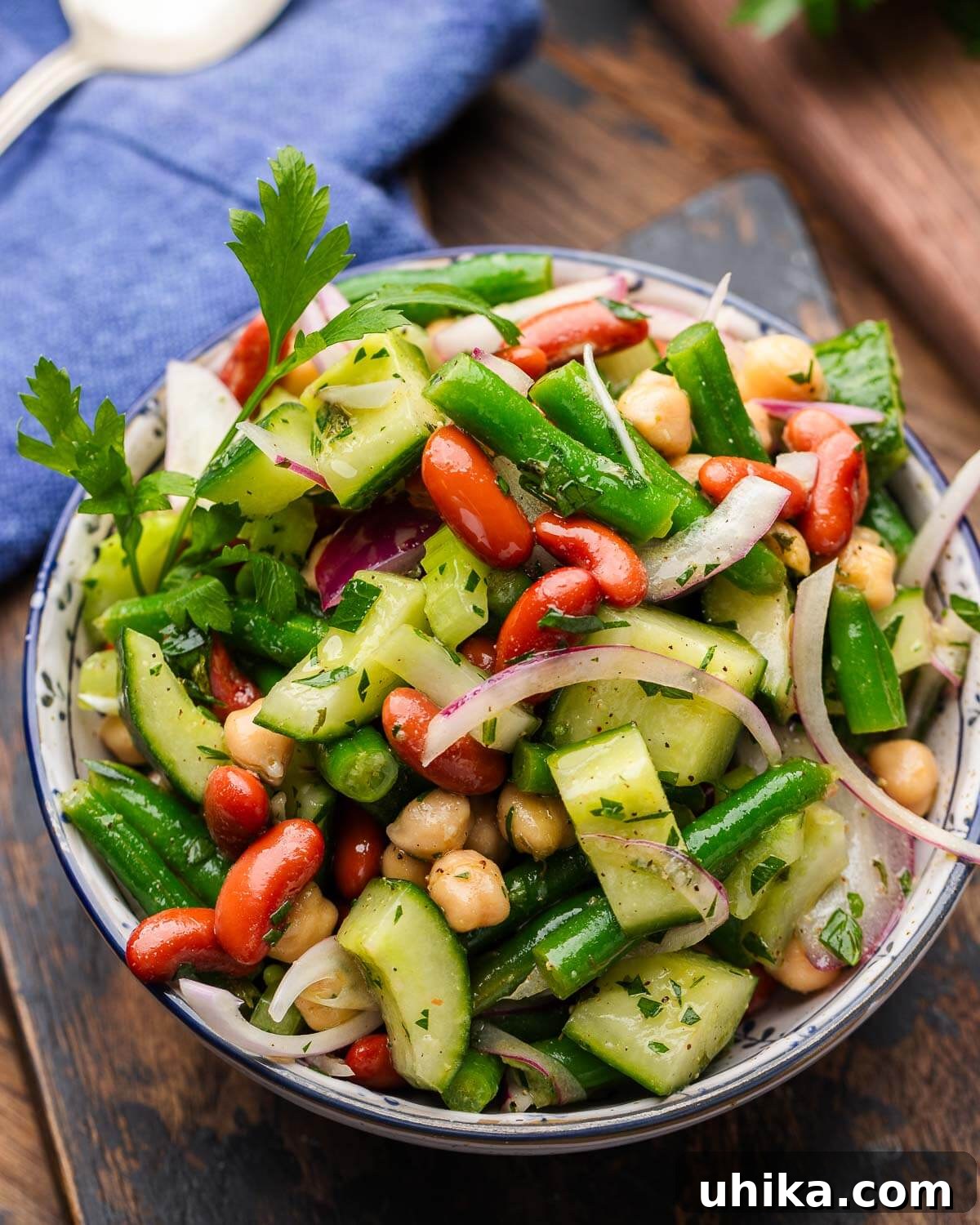 Zesty Mixed Bean Medley 2 A beautifully presented mixed bean salad in a pristine white bowl, garnished with fresh parsley.