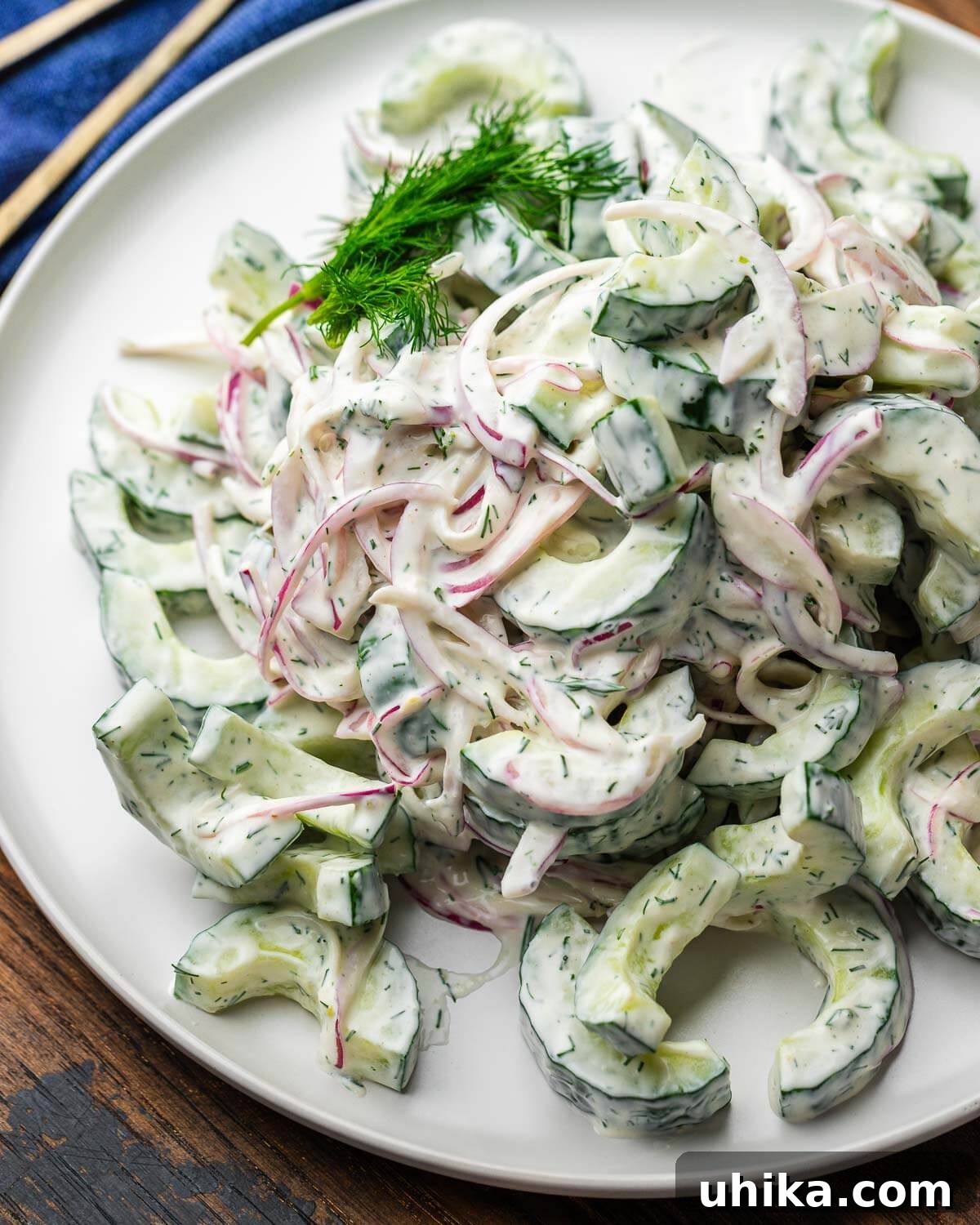 Cool Cucumber Delight 2 Creamy cucumber salad on white plate with dill garnish.