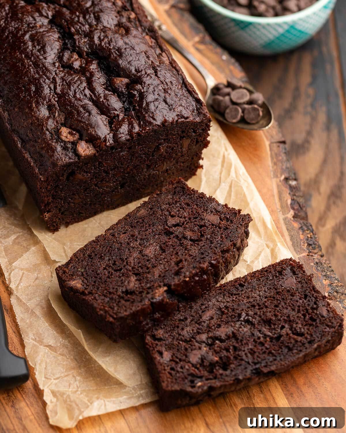 Decadent Chocolate Zucchini Loaf 2 Chocolate zucchini bread and slices on wooden board.