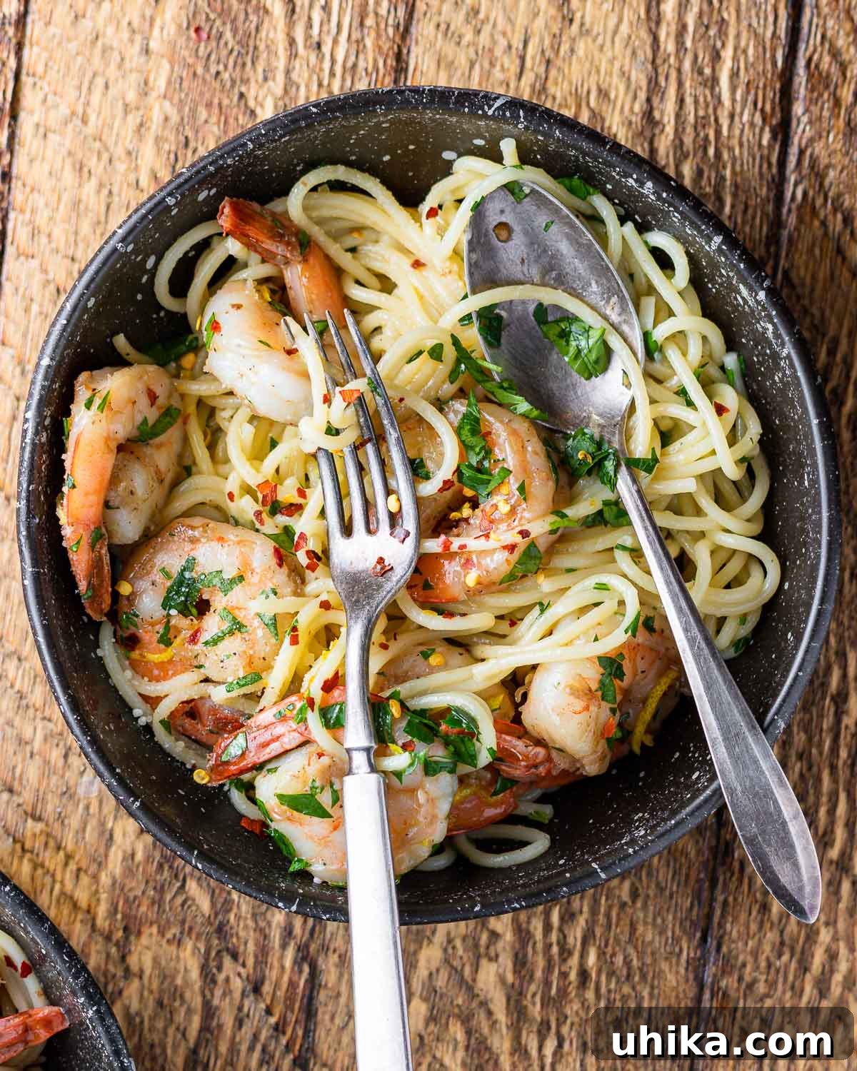 Vibrant Lemon Garlic Shrimp Pasta 2 Lemon garlic shrimp pasta in black plate on wood table.