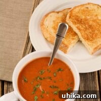 A close-up shot of creamy tomato basil soup with fresh basil garnish, presented in a rustic bowl.
