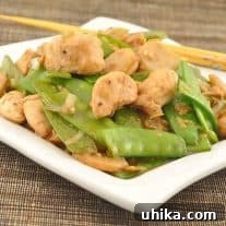 Close-up of Stir-Fried Chicken with Snow Peas and Ginger in a bowl