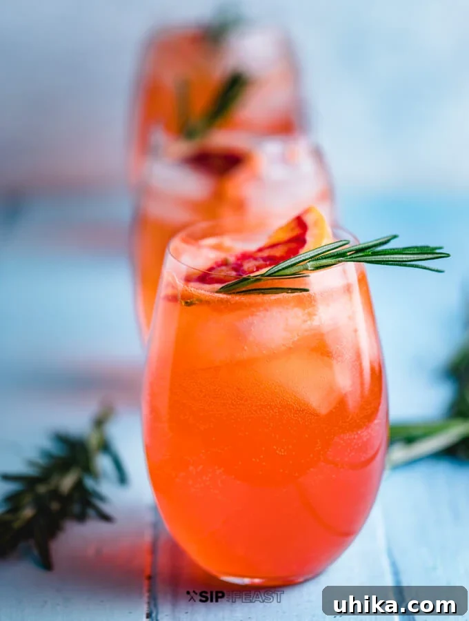 Aperol Spritz - A Vibrant and Refreshing Cocktail Three Aperol Spritz cocktails garnished with fresh orange slices and rosemary sprigs, ready to be enjoyed.