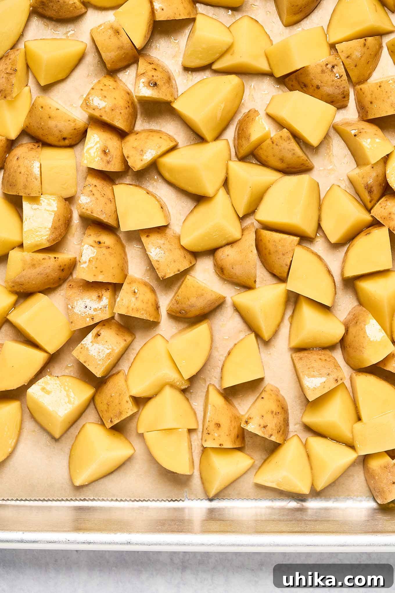 Baby yellow potatoes cut into chunks, ready to be par-baked before combining with bell peppers, onions, and Italian sausage.